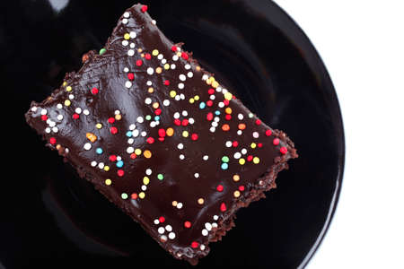 dessert : chocolate cake coated with chocolate on black saucer isolated over white backgroundの写真素材