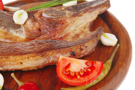 fresh grilled beef meat fillet on red wooden plate with tomatoes and capers isolated over white backgroundの写真素材