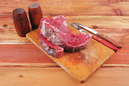 savory: red raw beef meat steak on wooden cutting board prepared for roastingの写真素材