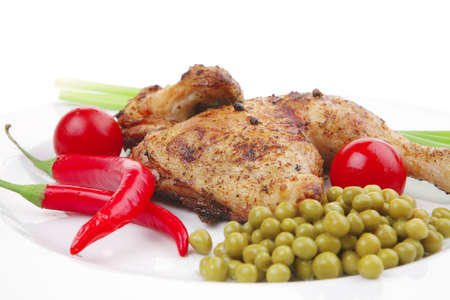 bbq : chicken ham garnished with green onion pens and red chili hot pepper on white plate isolated over white backgroundの写真素材