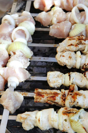 grilled and raw chicken shish kebab cooked on barbecue applianceの写真素材