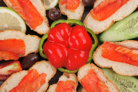 smoked salmon on baguette with olives and pepperの写真素材