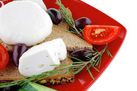 italian mozzarella and vegetables on red plateの写真素材