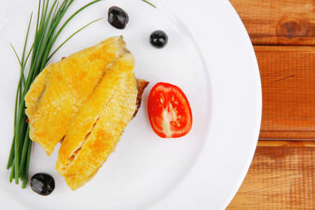 savory: fish fillet served on plate over wood with tomatoes,olives and breadの写真素材