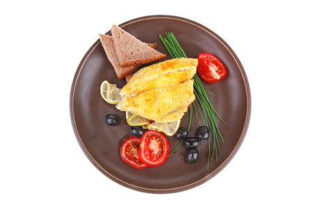 fish fillet with greek olives,tomatoes,chives and lemon on plateの写真素材