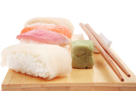 Japanese traditional cuisine - Different Types of Nigiri Sushi : Tuna (maguro) Salmon (sake) and Eel (unagi) with Wasabi  and chopstick on wooden plate isolated over white backgroundの写真素材