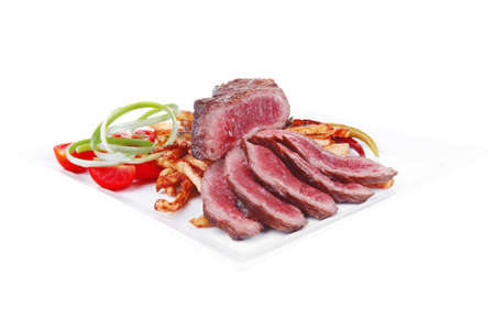 meat food : rare beef on potato chips with pepper and tomatoes over plate isolated on white backgroundの写真素材