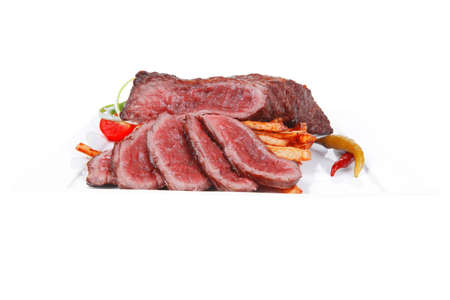 meat and potato : rare grilled beef steak served with pepper and tomato over plate isolated on white backgroundの写真素材