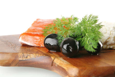 smoked fresh salmon piece with olives and white cheeseの写真素材
