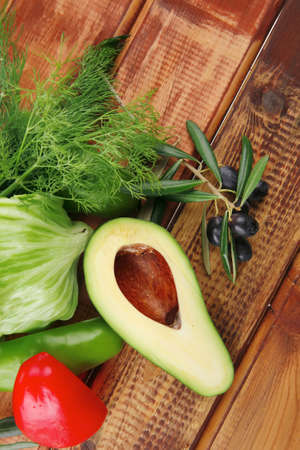 vegetables and raw olives over wooden tablesの写真素材