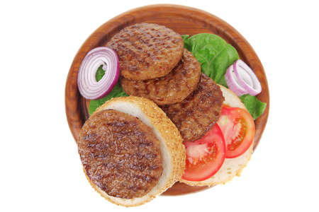 several large hamburger with loaf on wooden plate isolated over white backgroundの写真素材