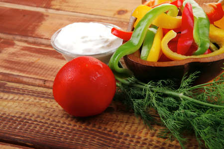 raw peppers sliced on wooden table with sour creamの写真素材