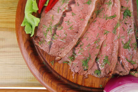 hot beef on wooden plate over wood tables