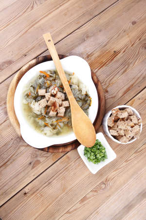 hot fresh diet vegetable soup with rye bread crackers over wood table on standの写真素材