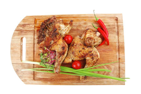 meat food : roasted chicken legs garnished with green sprouts and peppers on wooden plate isolated over white backgroundの写真素材