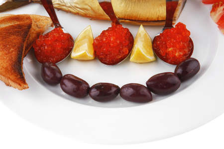 fish olives and red caviar on white plateの写真素材