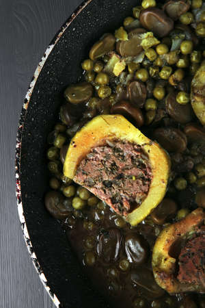 homemade cuisine: zucchini filled meat on peas and beans cooked into pan over blue woodの写真素材