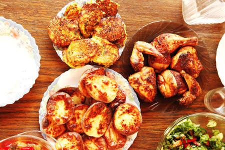 homemade food: salads and grilled chicked served over wooden tablesの写真素材