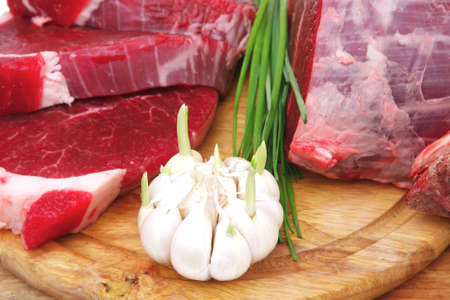 butchery : fresh raw beef lamb big rib and fillet ready to cooking with green stuff on wooden plate isolated over white backgroundの写真素材