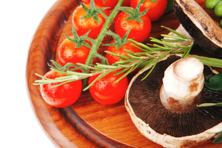 vegetables and olives over wooden plate on whiteの写真素材