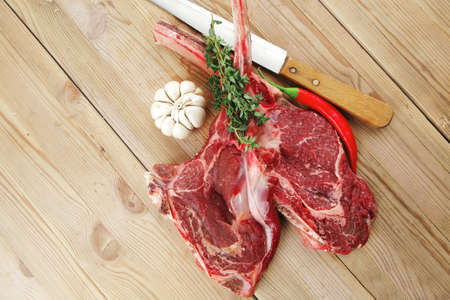 fresh raw meat : fresh red beef ribs with thyme , garlic and red chili pepper over wooden tableの写真素材