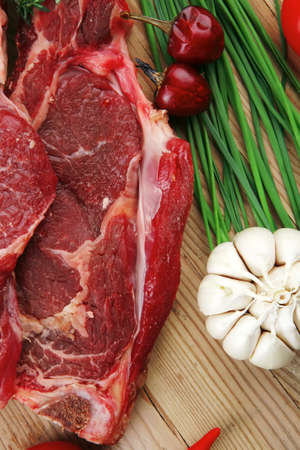 fresh raw meat : fresh red beef ribs with thyme , red chili pepper , cherry tomato , and garlic on wooden boardの写真素材