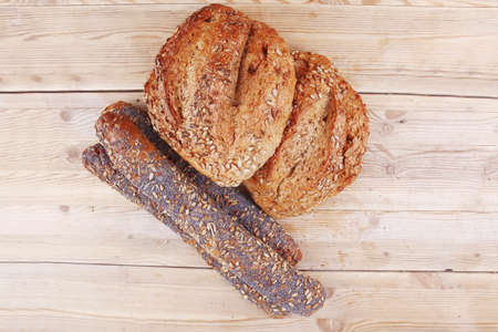 delicacy french rye breads and baguettes topped with sunflower and poppy seeds over wooden table