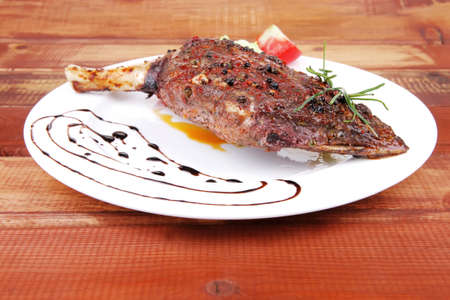 meat on wooden plate : roast shoulder on wood with tomatoes chives and green lettuce on white plateの写真素材
