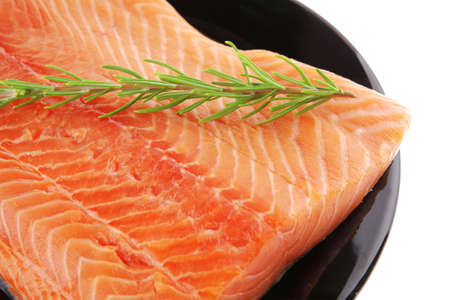piece of salmon fillet on black plate over white and rosemaryのeditorial素材