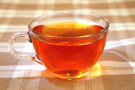 hot tea in transparent mug on tableclothのeditorial素材