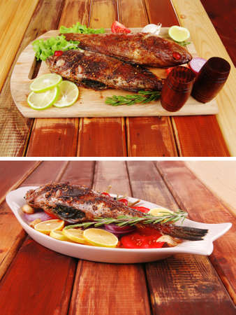 roasted sea fish and castors on wood with tomatoes, lemon and green lettuce saladのeditorial素材
