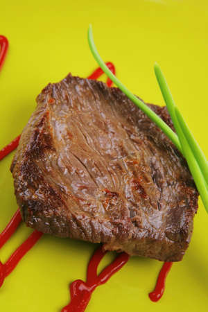 meat savory : grilled beef fillet mignon on green plate with chives and ketchup over wooden tableの写真素材