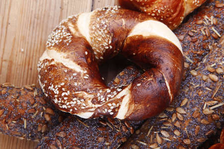 fresh mix of baguettes , pretzels and wheat bread, on wooden tableの写真素材