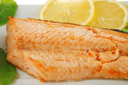 big grilled salmon steak over white plate