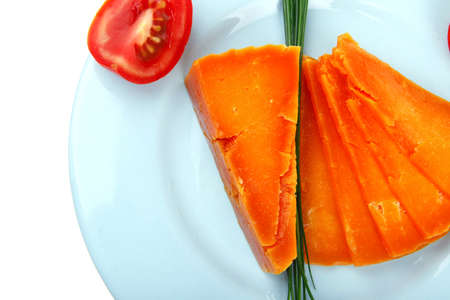 old delicious cheddar cheese chop with slice on blue plate with tomatoes and chives isolated over white backgroundの写真素材