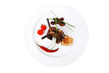roast ribs with vegetables on white plate