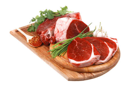 butchery : fresh raw beef lamb big rib and fillet ready to cooking with green stuff on wooden plate isolated over white backgroundの写真素材
