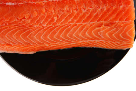 big salmon chunk on black plate over whiteの写真素材