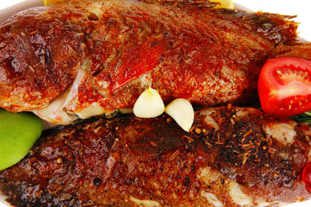 savory on plate: two fried fish served with tomatoes lemon and rosemary
