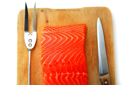 fresh raw salmon fish piece over wooden board isolated on white backgroundの写真素材