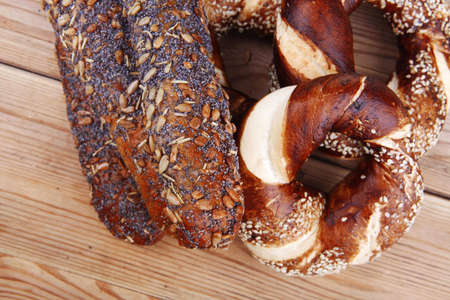 mix of fresh homemade baguettes , pretzels and wheat loafs, on wooden table