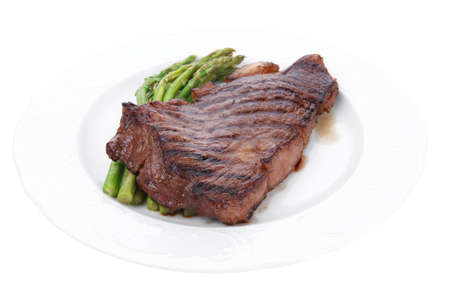 meat table : grilled beef fillet with asparagus served on white plate isolated over whiteの写真素材