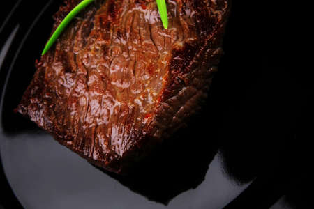 meat savory : grilled beef fillet mignon served on black plate isolated over white background with chili pepperの写真素材