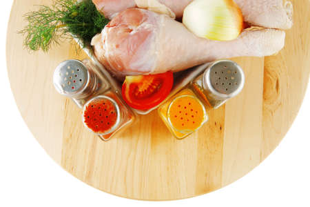uncooked chicken drumstick and different spices on woodの写真素材