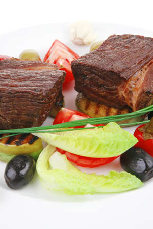 meat savory : beef fillet mignon grilled and garnished with baked apples and tomatoes on white plate isolated over white backgroundの写真素材