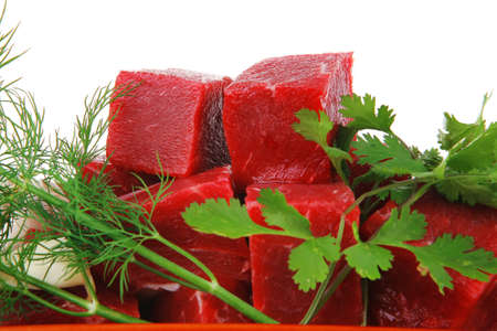 slices of raw fresh beef meat fillet in a ceramic dish with onions and peppers isolated over white...