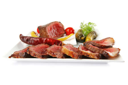 hot grilled meat and vegetables served on platesの写真素材