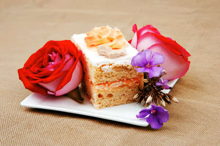 sweet food: cheese cream cake piece on white dish with rosesの写真素材