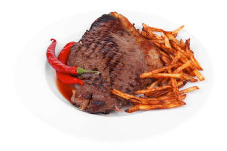 meat food : grill beef steak with potato chips and dry red hot chili peppers  on white round plate isolated on white backgroundの写真素材