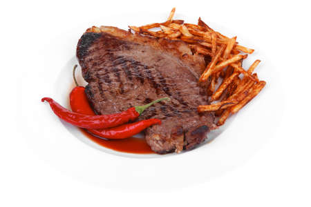 entree : grill beef meat steak on white round plate with dry hot chili pepper and potato chips isolated on white backgroundの写真素材